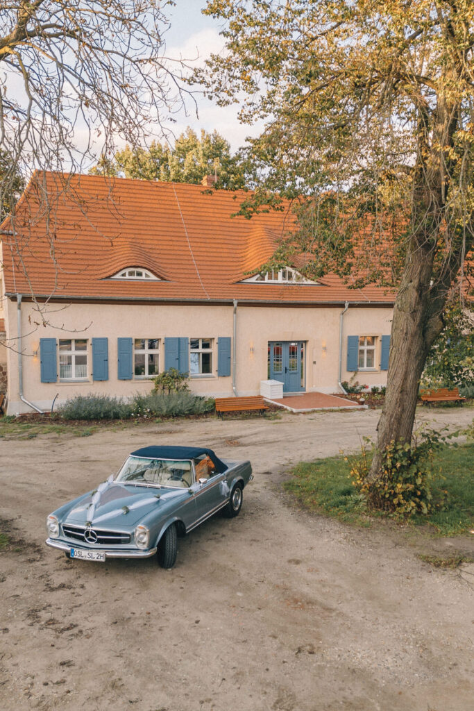 Foto von einem Auto welches für eine Hochzeit geschmückt wurde, vor dem Herrenhaus des Rittergut Kemmen.